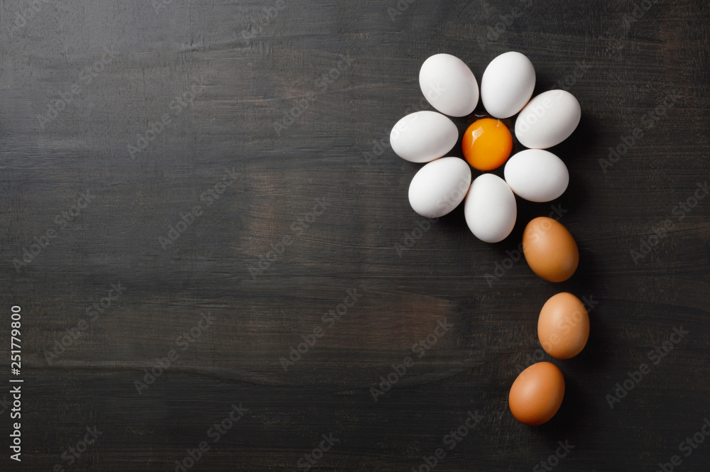 Daisy flower shaped with eggs on black background Daisy flower shaped with eggs on black background