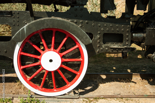 large steel wheels of old steam locomotive red with white outline photo