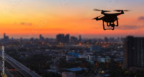 Photography Silhouette of drone flying above city at sunset