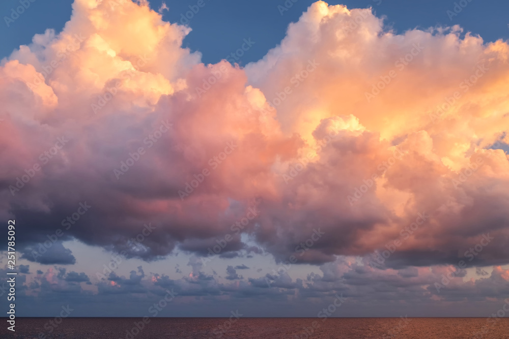 Giant pink cloud on a sunrise morning time floating over the sea after thunderstorm.