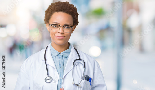 Young african american doctor woman wearing medical coat over isolated background Hands together and fingers crossed smiling relaxed and cheerful. Success and optimistic
