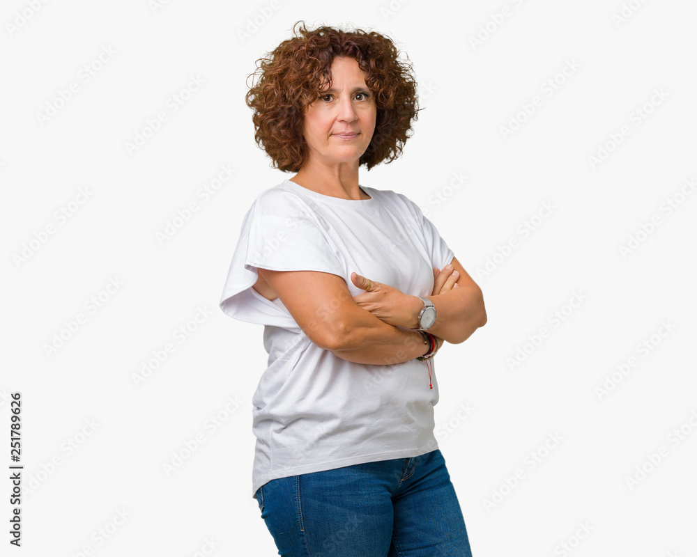 Beautiful middle ager senior woman wearing white t-shirt over isolated background Relaxed with serious expression on face. Simple and natural with crossed arms Beautiful middle ager senior woman wearing white t-shirt over isolated background Relaxed with serious expression on face. Simple and natural with crossed arms