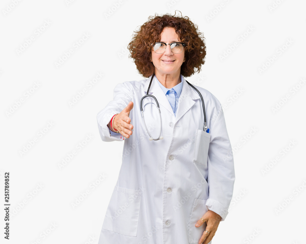 Middle ager senior doctor woman over isolated background smiling friendly offering handshake as greeting and welcoming. Successful business. Middle ager senior doctor woman over isolated background smiling friendly offering handshake as greeting and welcoming. Successful business.