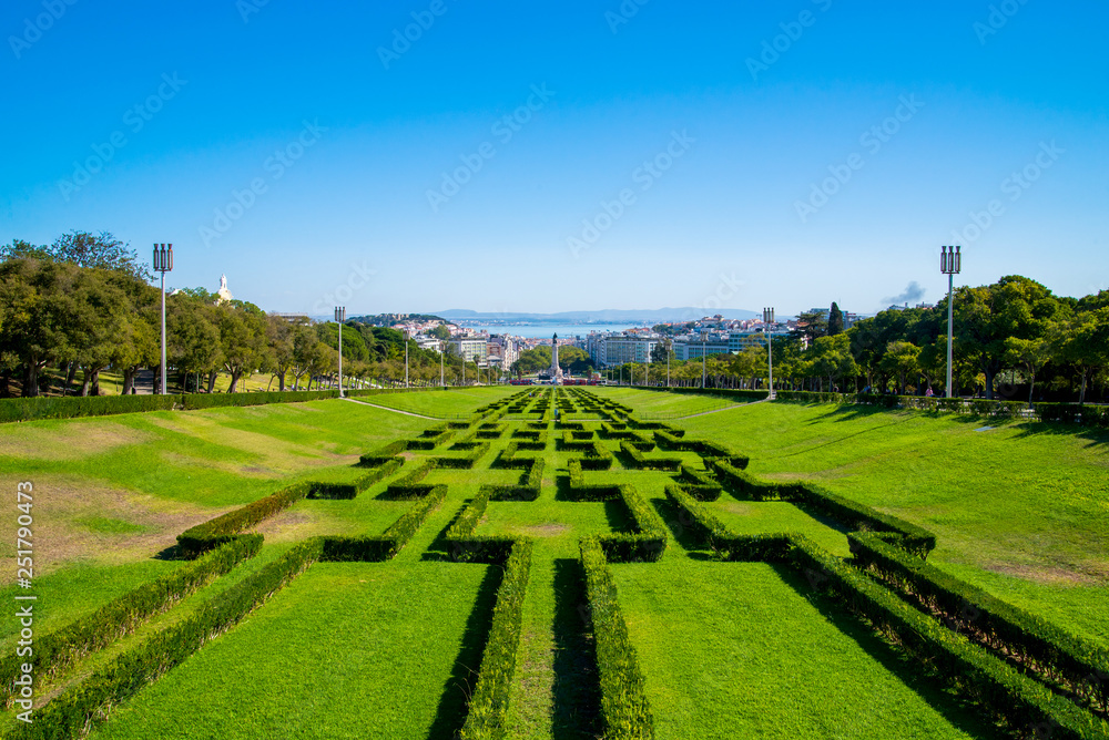 View of the labyrinth of Eduardo VII park and gardens, the largest park in the center of Lisbon and Tagus river in the background, in Lisbon, Portugal