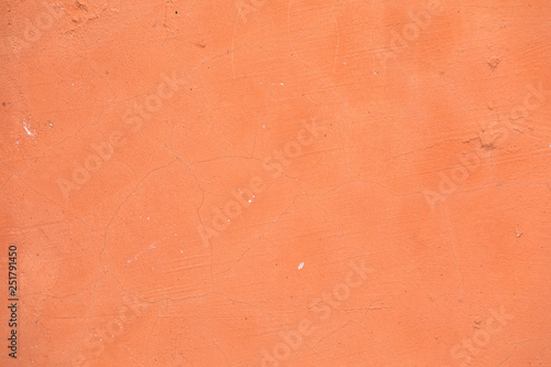 Bright rich texture of peach color. Cement a background of a weather-beaten wall with the cracked structure