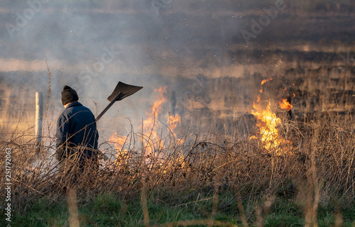 Bursdon Moor, Hartland,North Devon, England, UK. February 2019. Man using a rubber fire beater tool at the annual  burning of gorse and scrub