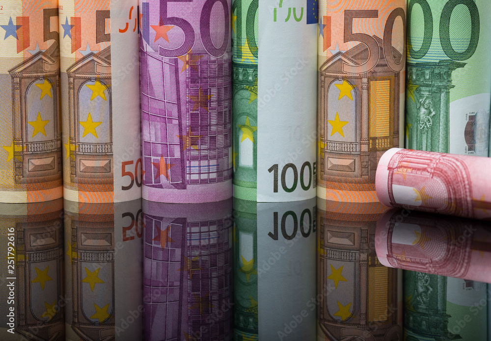 European paper money in rolls on black background with reflection. Business and financial concept with euro banknotes. European paper money in rolls on black background with reflection. Business and financial concept with euro banknotes.