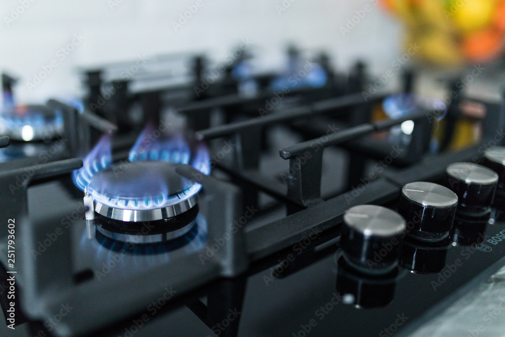 Cooktop with burning gas ring. Gas cooker with blue flames. Cooktop with burning gas ring. Gas cooker with blue flames.
