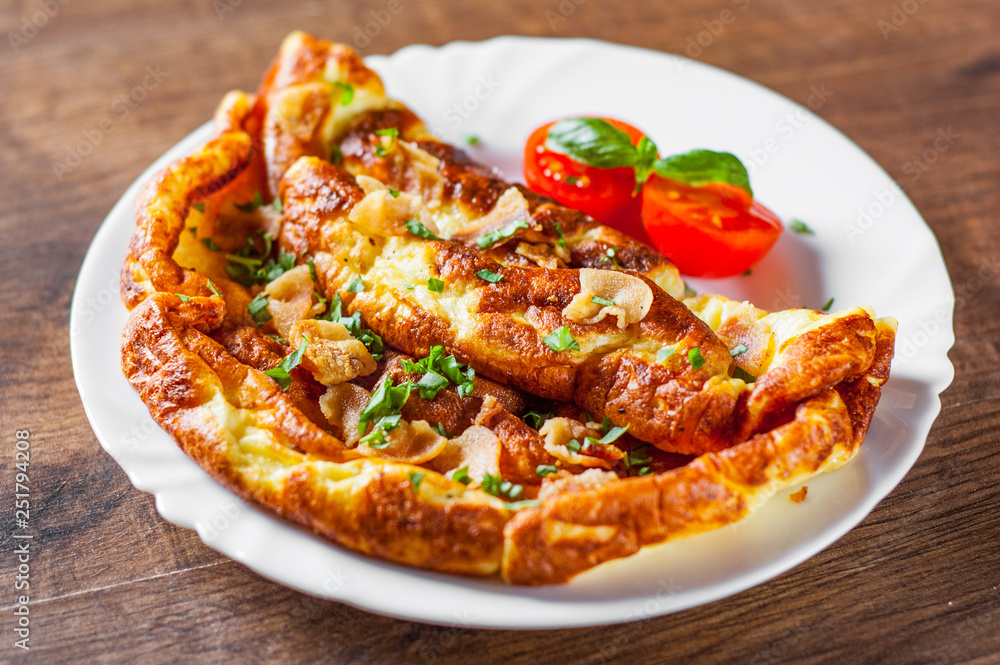 omelette with bacon in a white plate on wooden table omelette with bacon in a white plate on wooden table
