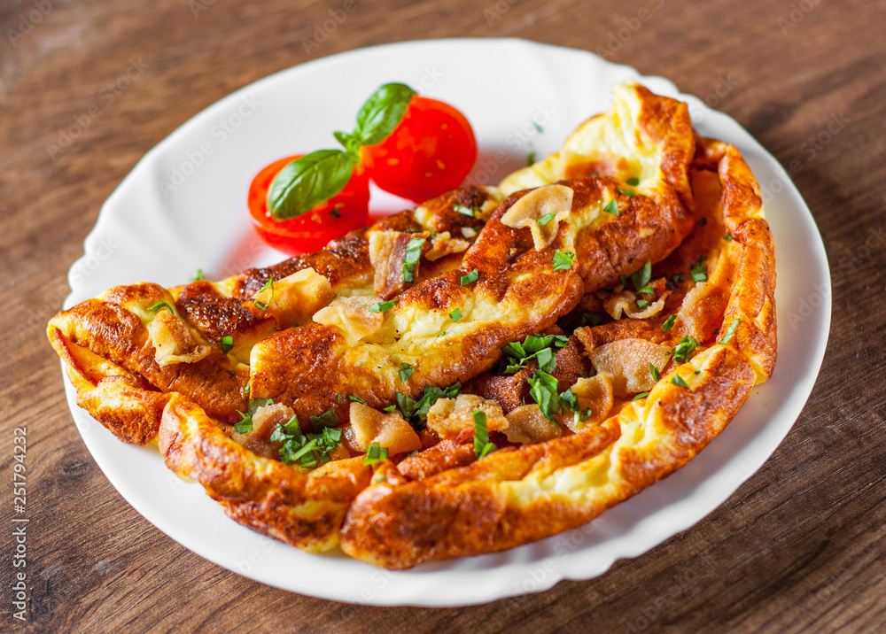 omelette with bacon in a white plate on wooden table omelette with bacon in a white plate on wooden table