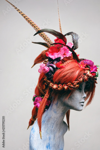 Mannequin in creative wig with flowers and feathers  photo