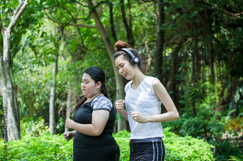 Asian Thin and overweight woman jogging in park, fat and fitness girls running workout together,exercises