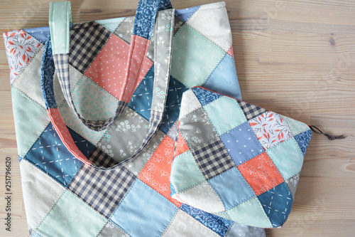 Quilted tote bag and notion pouch on the wooden table	