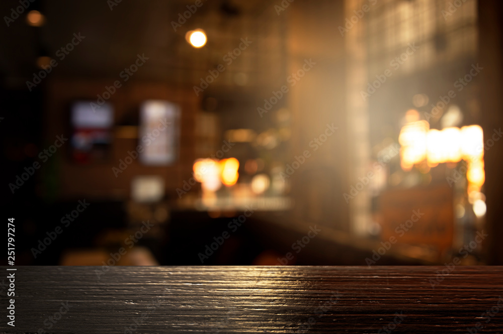 top of black wood with blur light of bar or pub party in the dark night background