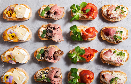 Different types of bruschetta on a gray concrete background