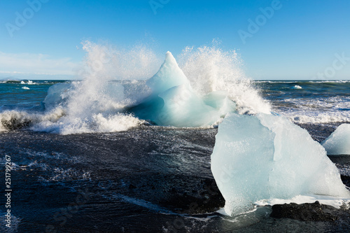 Surf crashing into ice chunks washed on Diamond Beach near glacier lagoon of Jokulsarlon, Iceland, IS, Europe photo