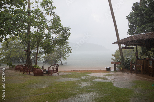 Tropical rain on the beach in the recreation area by the sea