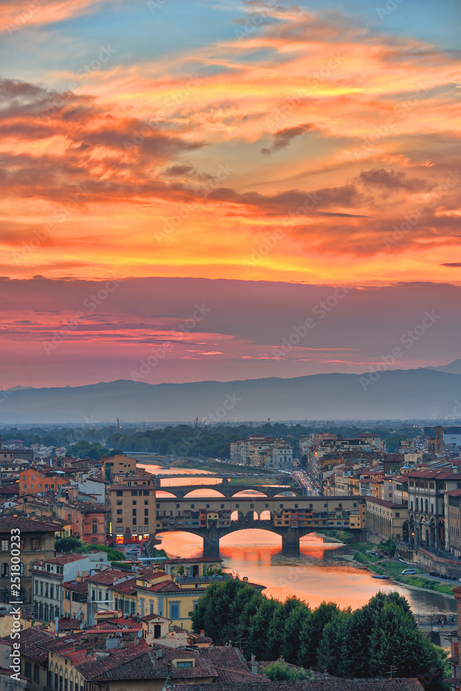 View of the River Arno and famous bridge Ponte Vecchio. Amazing evening golden hour light. Beautiful gold sunset in Florence, Italy