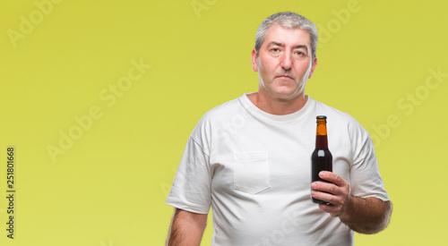 Handsome senior man drinking beer bottle over isolated background with a confident expression on smart face thinking serious