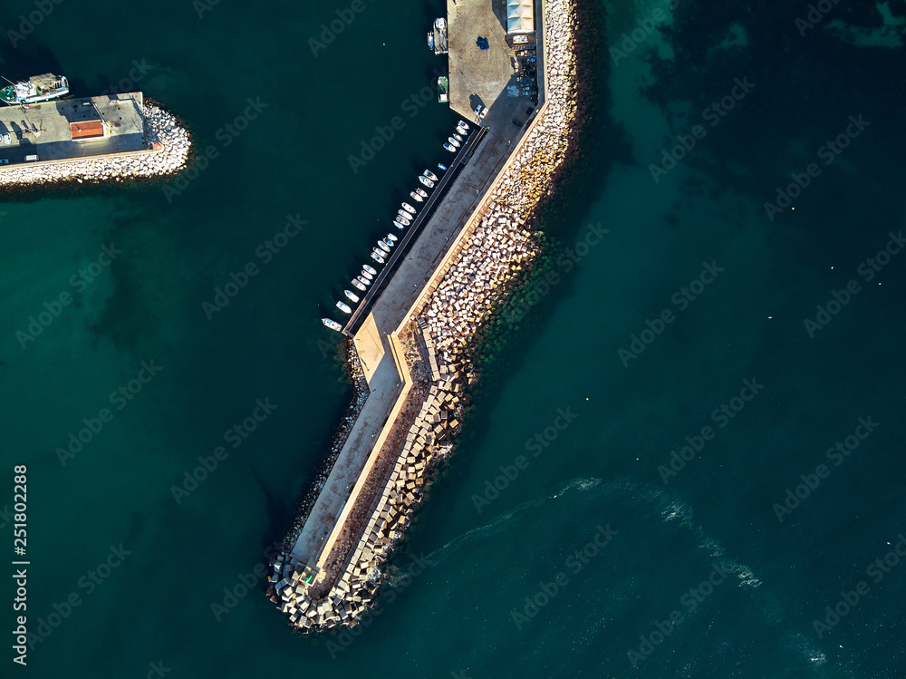 Aerial drone point of view pier mole breakwater and turquoise green water of the Mediterranean sea. Calpe resort town marina photo take from above. Province of Alicante, Costa Blanca, Spain Aerial drone point of view pier mole breakwater and turquoise green water of the Mediterranean sea. Calpe resort town marina photo take from above. Province of Alicante, Costa Blanca, Spain