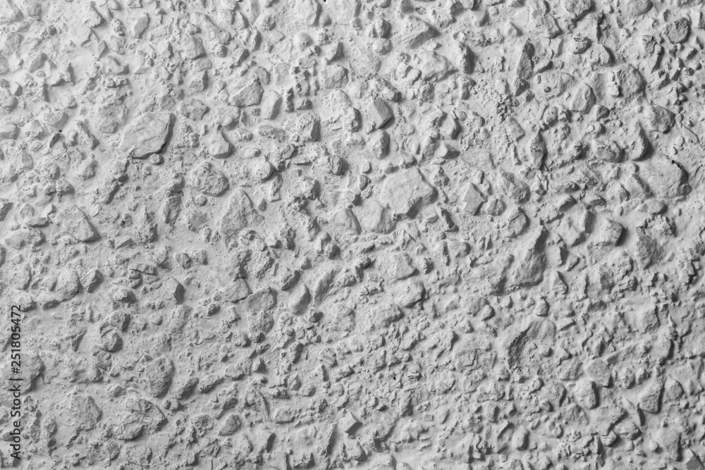 Black and white whitewashed concrete wall interspersed with stones