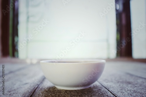 Fototapeta Naklejka Na Ścianę i Meble -  Hot white tea cup closeup on vintage wood table style in the home