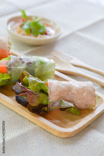 Salad roll with Green and red oaks, slice carrot, sausage, tuna on wooden tray with spicy dipping (Chili, Garlic and fish sauce). Healthy food.