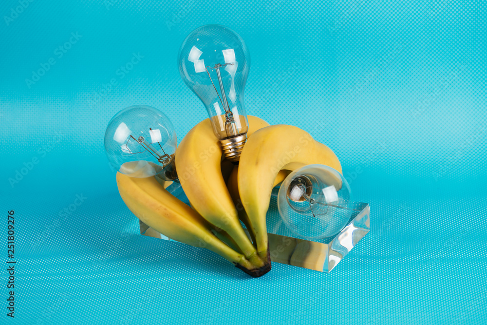 Fototapeta premium Different kinds of fruit and electric bulbs on blue background.
