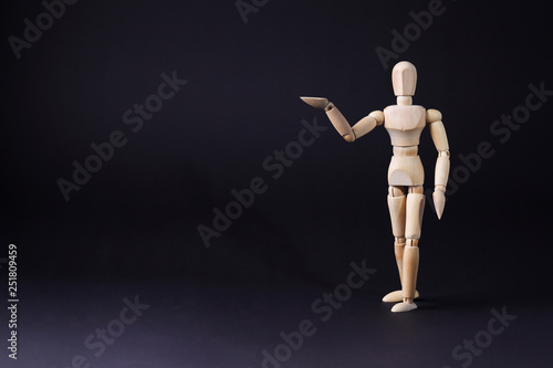 A wooden mannequin shows with his hand. The concept of pointing at someone with your finger. The mannequin will stretch out his hand. Wooden man concept. Wooden mannequin © Olivkairishka