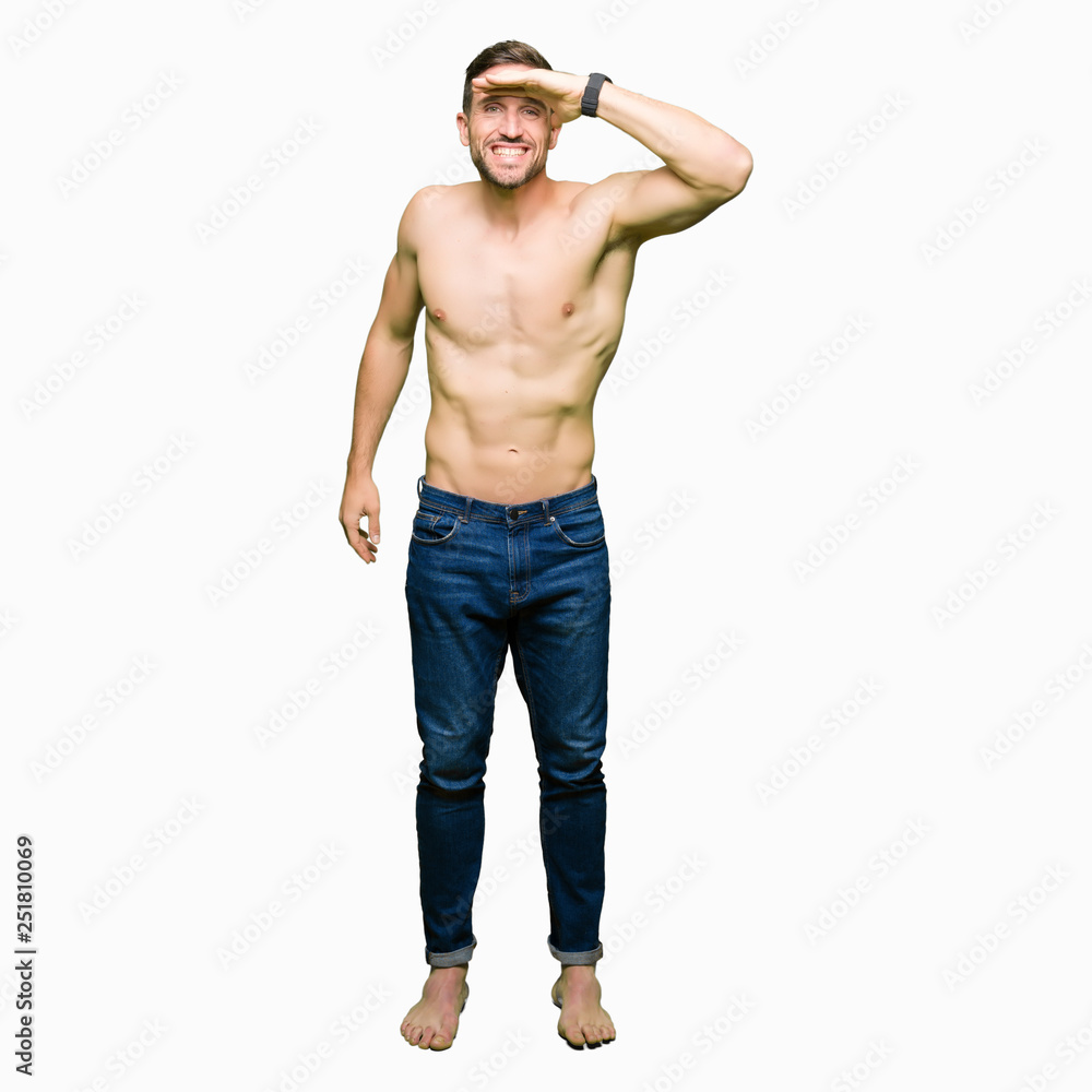 Fototapeta premium Handsome shirtless man showing nude chest very happy and smiling looking far away with hand over head. Searching concept.