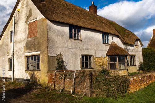 A run down English farmhouse with a thatched roof