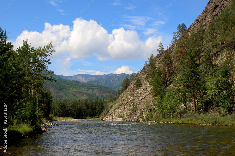 Siberian river Barguzin in the upper summer day in one of its turns between the slopes of the mountains
