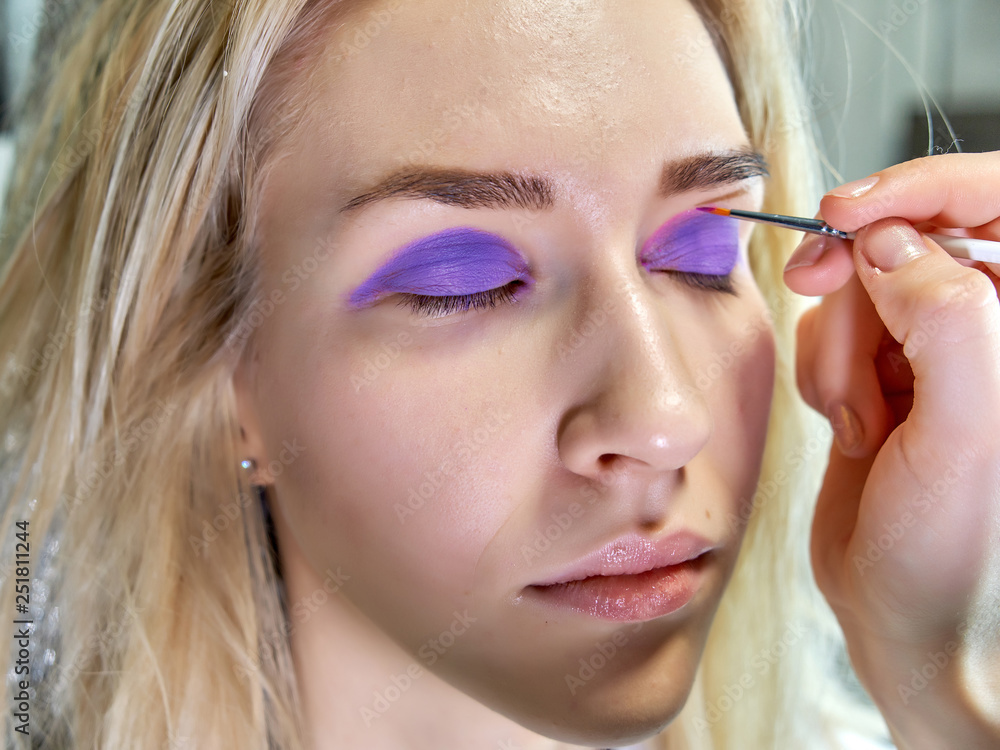 Concept work of a beautician cosmetologist in with office. Makes hair, applies makeup on a gray background. Concept work of a beautician cosmetologist in with office. Makes hair, applies makeup on a gray background.