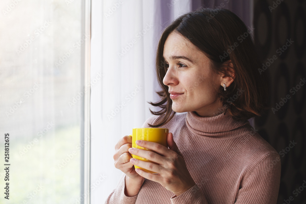 portrait of pretty young woman holding ceramic yellow cup and drinking morning tea or coffee portrait of pretty young woman holding ceramic yellow cup and drinking morning tea or coffee