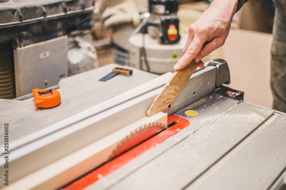 Carpentry the master saws the wooden bar safety