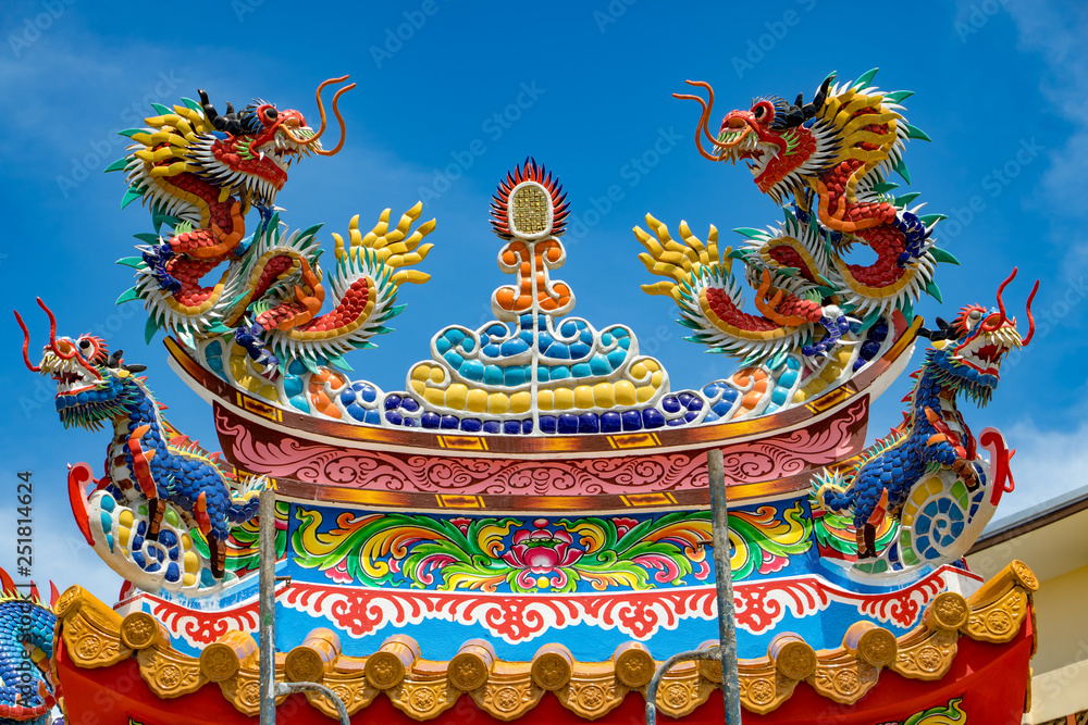 The colorful decoration on portal in Chinese temple, against blue sky, Thailand.