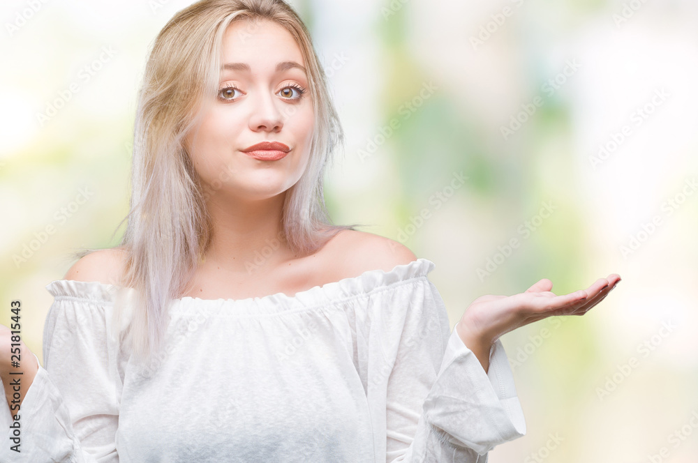 Young blonde woman over isolated background clueless and confused expression with arms and hands raised. Doubt concept. Young blonde woman over isolated background clueless and confused expression with arms and hands raised. Doubt concept.