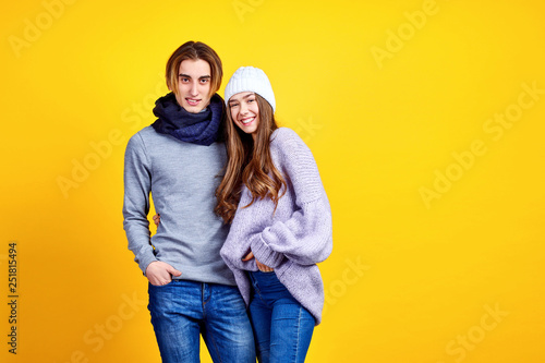 Couple in casual clothes posing in jeans type commercial fashion style on yellow wall © zamuruev