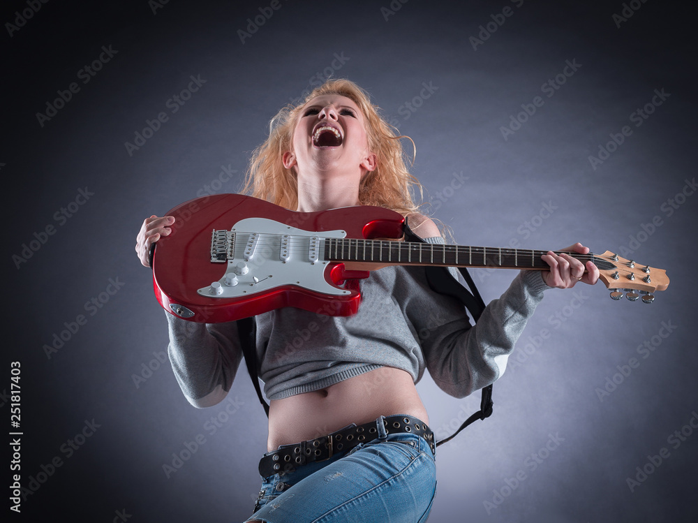Attractive girl emotionally playing the electric guitar. Attractive girl emotionally playing the electric guitar.