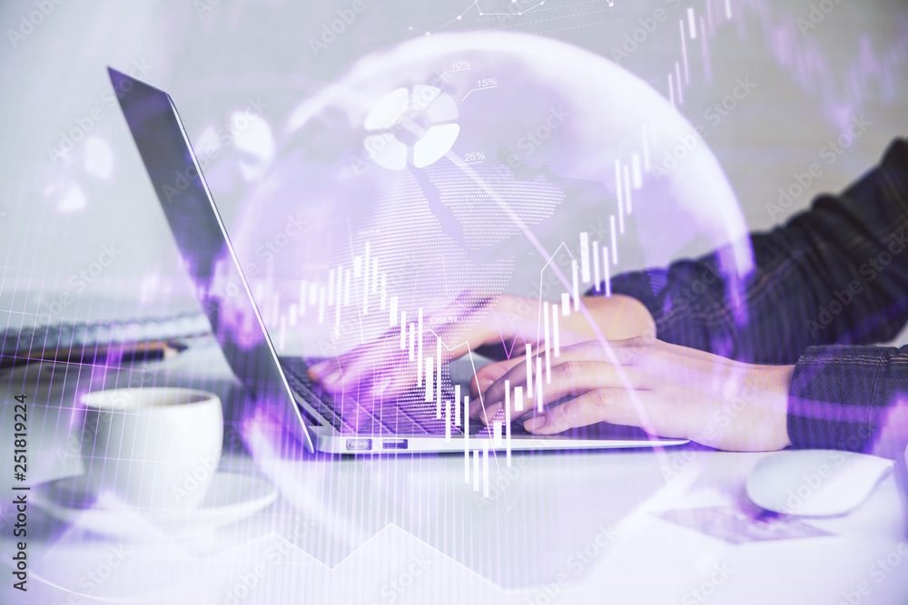 Hands typing on laptop. Business and Financial concept. Double exposure of stock market charts.
