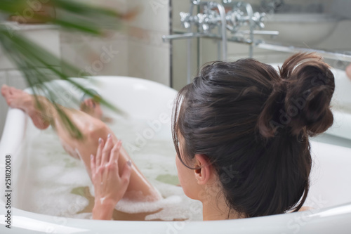 young beautiful brunette woman takes bath