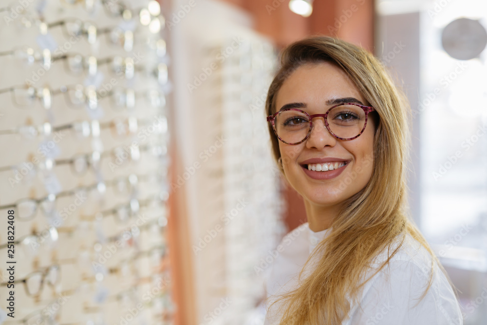 Portrait of woman wearing eyeglasses in optic store - obrazy, fototapety, plakaty 