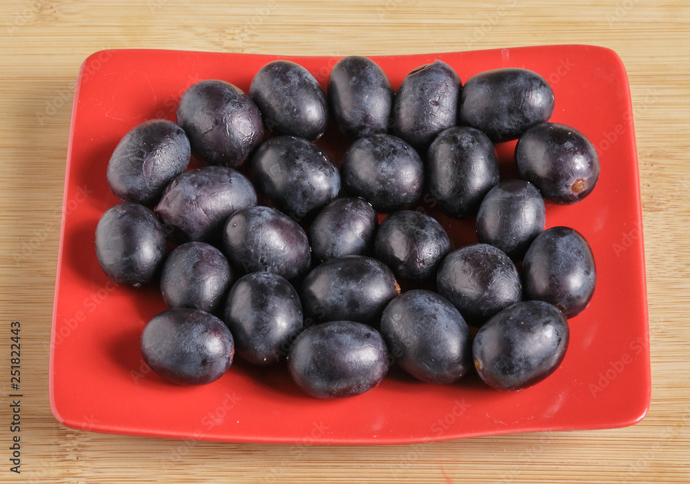 Black grapes on a plate. Drops of water on the grapes. Black grapes on a plate. Drops of water on the grapes.