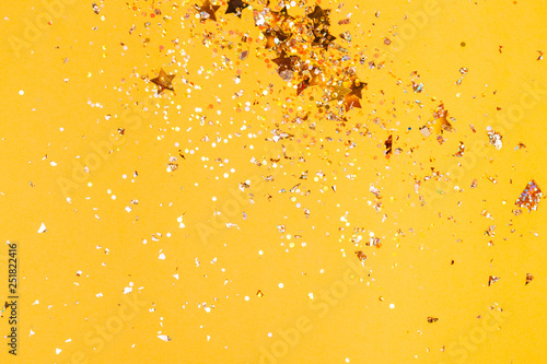 Colorful yellow confetti background. Vibrant and holiday. Top view, flat lay.