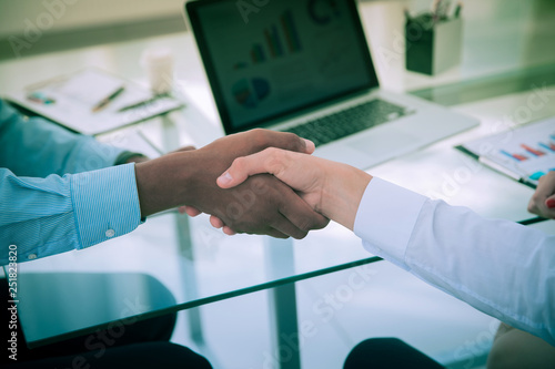 closeup.strong financial partners shaking hands over a Desk