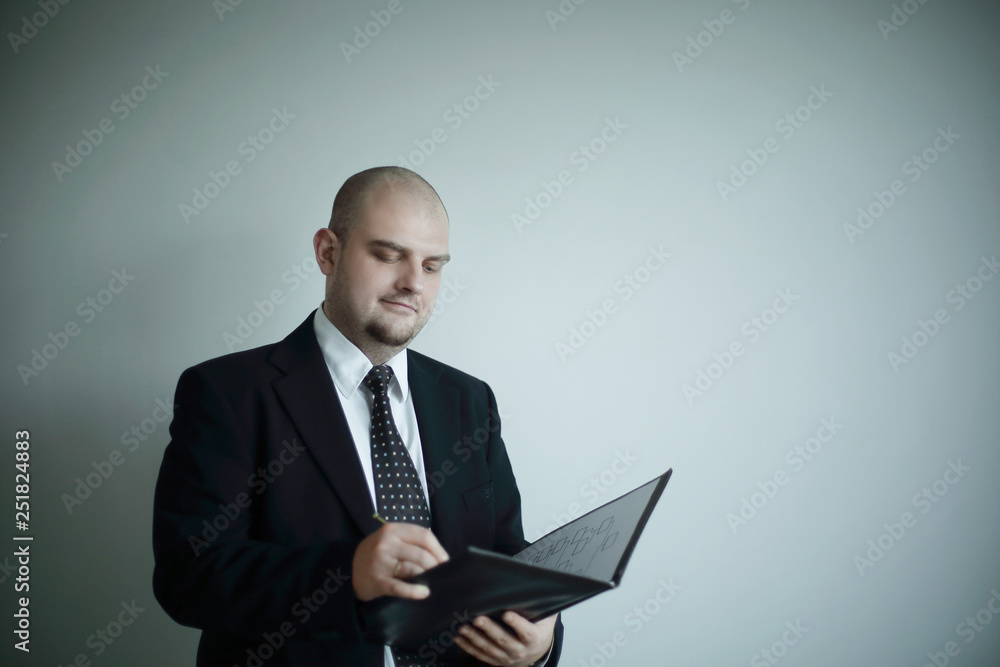 serious businessman signs a document .isolated on grey background serious businessman signs a document .isolated on grey background