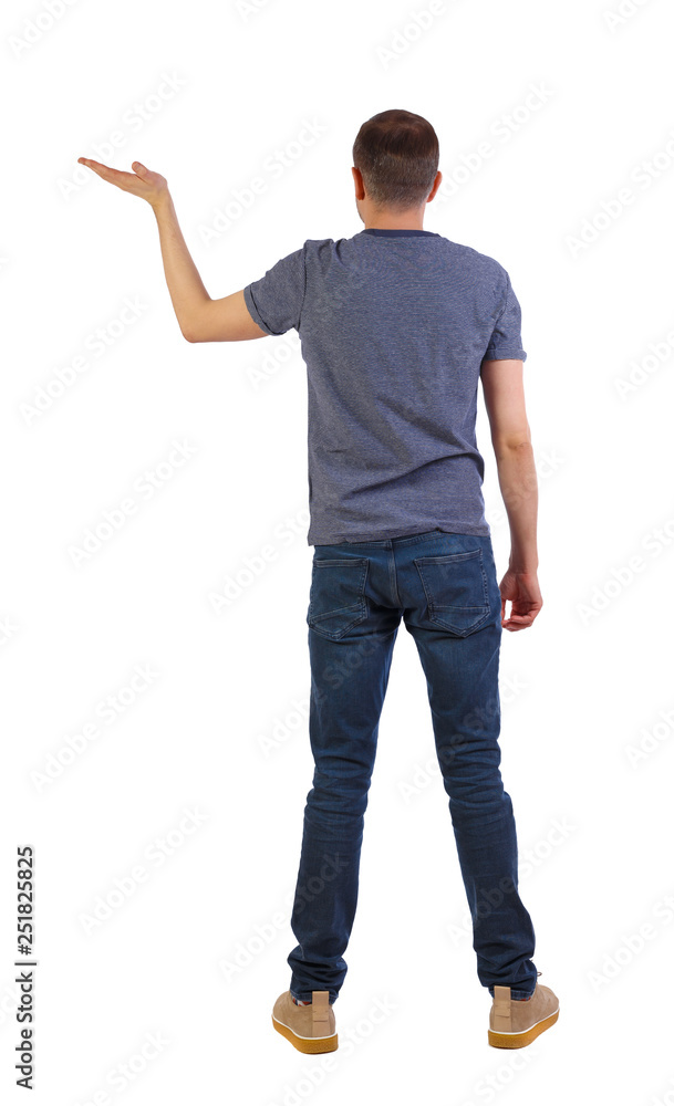 Back view of man looking at wall and Holds hand up. Back view of man looking at wall and Holds hand up.
