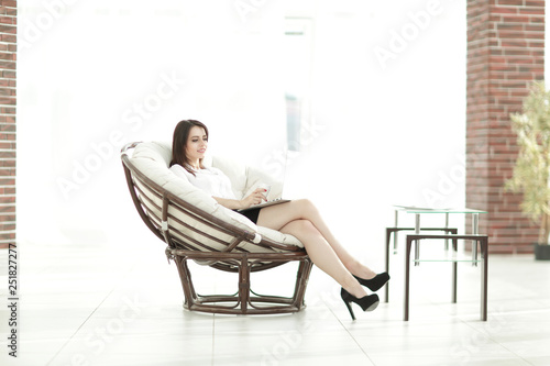 business woman with documents sitting round a comfortable chair