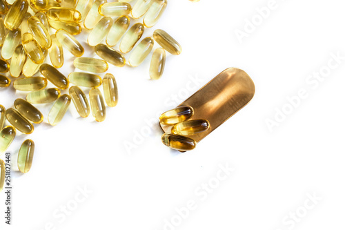 A lot of fish oil omega 3 6 9 capsules on a brass golden spoon. sports nutrition healthy food and lifestyle top view
