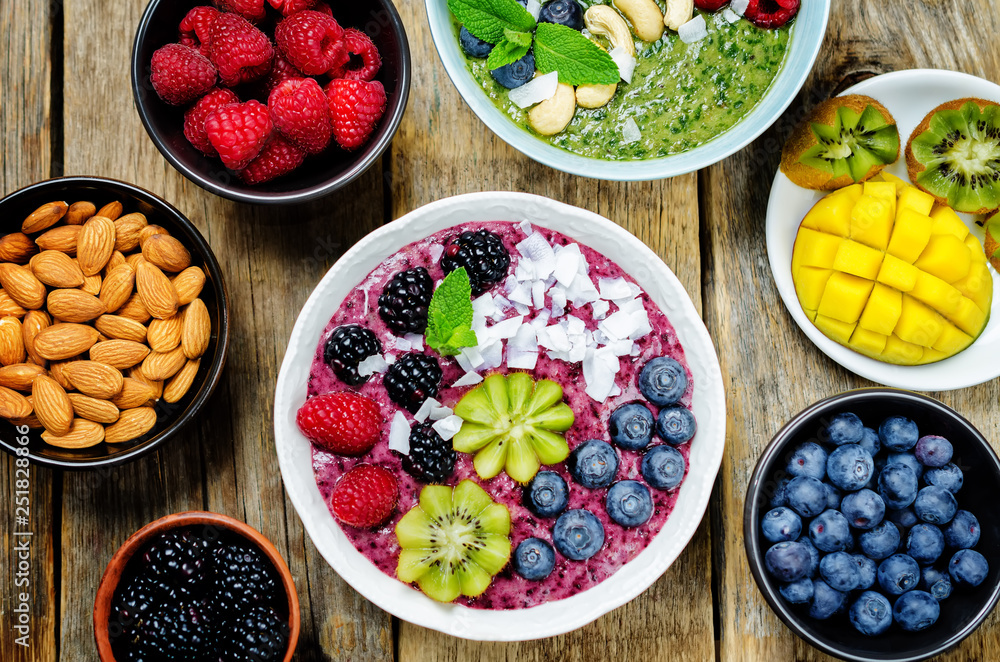 Smoothie breakfast bowls with berries, seeds and nuts on a wood background Smoothie breakfast bowls with berries, seeds and nuts on a wood background